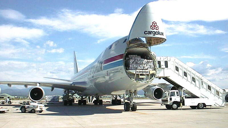 A detailed cost breakdown table on a tablet, showing various factors affecting moving prices, with a blurred background of a moving crew.