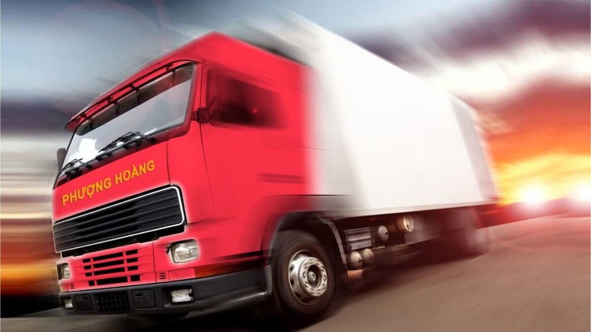 Professional movers in Kiến Vàng uniforms carefully wrapping a large wooden table with protective plastic and moving blankets inside an apartment, with stacked boxes in the background. Highly detailed, realistic.